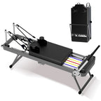 Foldable black Pilates reformer with colored resistance springs, steel frame, and sliding carriage, shown set up and folded.