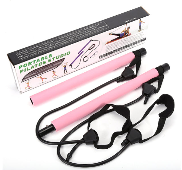 Portable Pilates bar set with pink foam-covered metal rods, black resistance bands, and soft foot straps in a box.