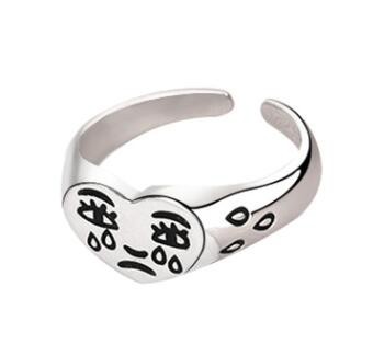 Silver adjustable ring featuring a heart-shaped face with engraved black "crying" face design and teardrop accents.