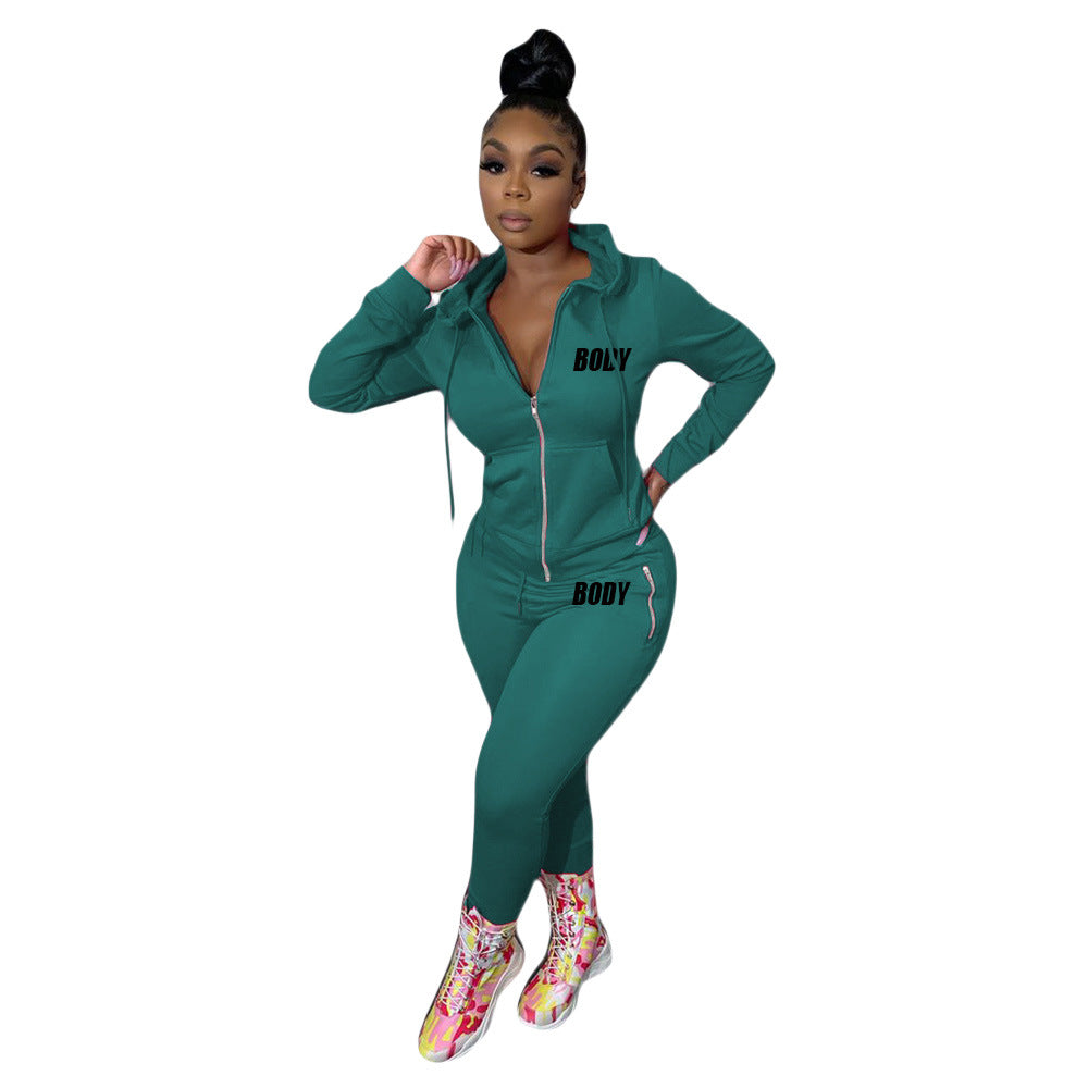 A woman wears a teal green zip-up hoodie and matching leggings set with "BOLY" and "BODY" text prints.