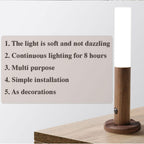 Cylindrical wooden LED motion sensor lamp with a soft white light, resting on a round base on a wooden surface.