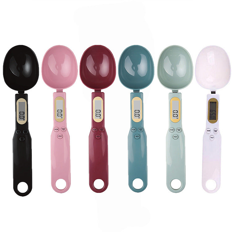 Six electronic digital kitchen spoon scales in black, pink, maroon, blue, green, and white.