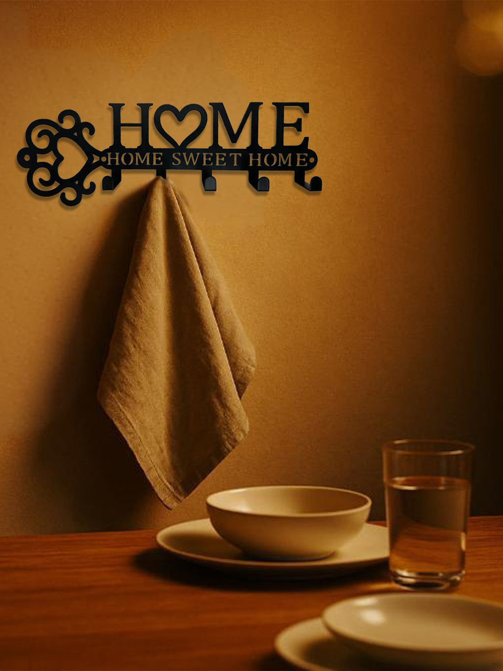 Black metal wall hook set featuring a "HOME SWEET HOME" design with a heart, mounted on a wall with a hanging cloth.