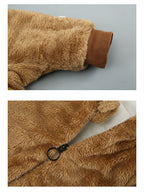 Close-up of a tan, fuzzy, fleece-lined baby onesie featuring ribbed cuffs and a sturdy front zipper closure.