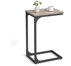 C-shaped side table with a grey wood-grain top and black metal frame, holding a small vase and a white coffee cup.