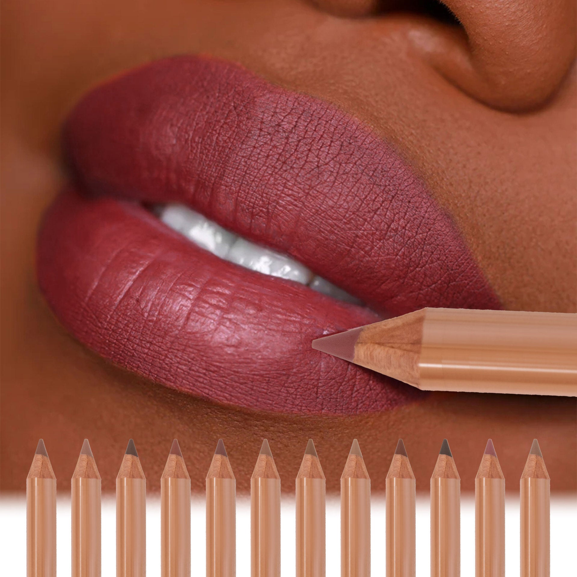 Close-up of a model wearing matte dark nude lipstick with a row of wooden lip liner pencils in various nude shades.