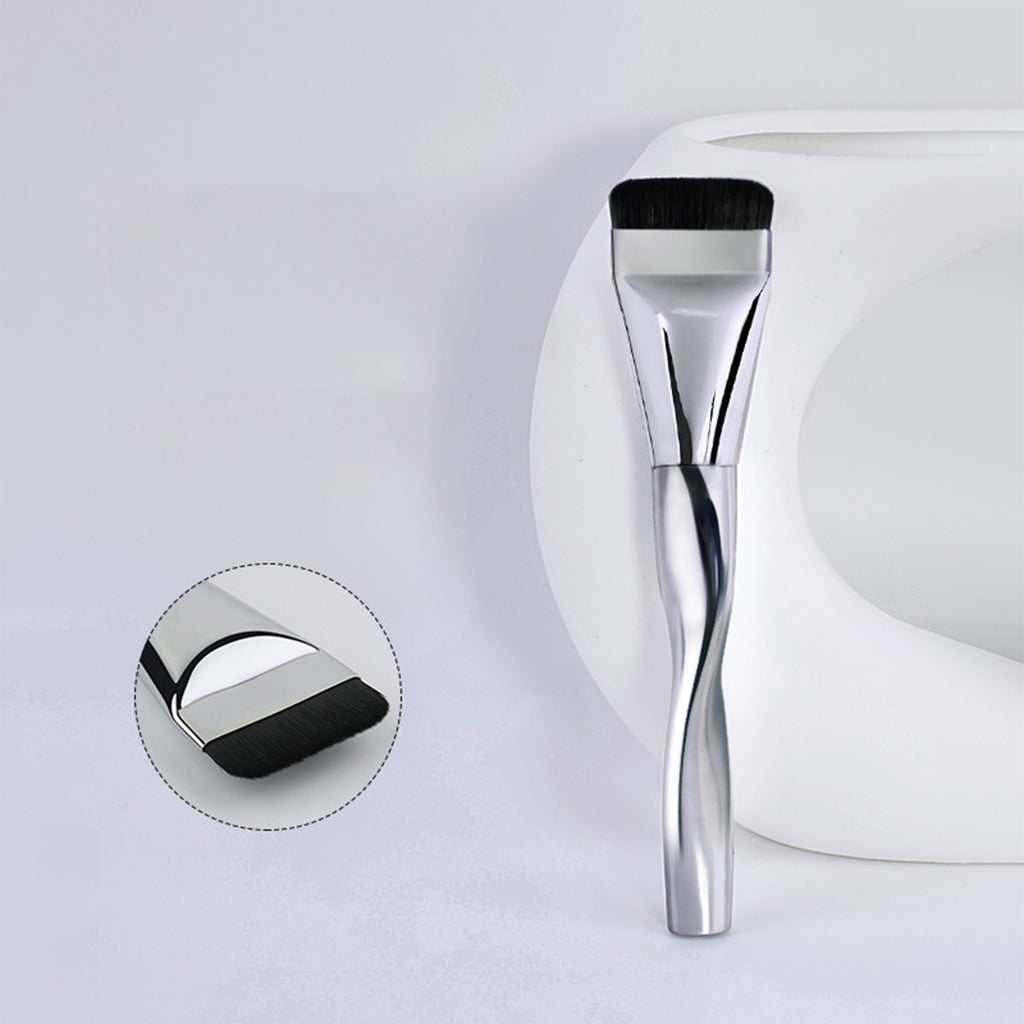 Ultra-thin foundation brush with a wavy silver metallic handle and flat, dense black bristles for traceless application.