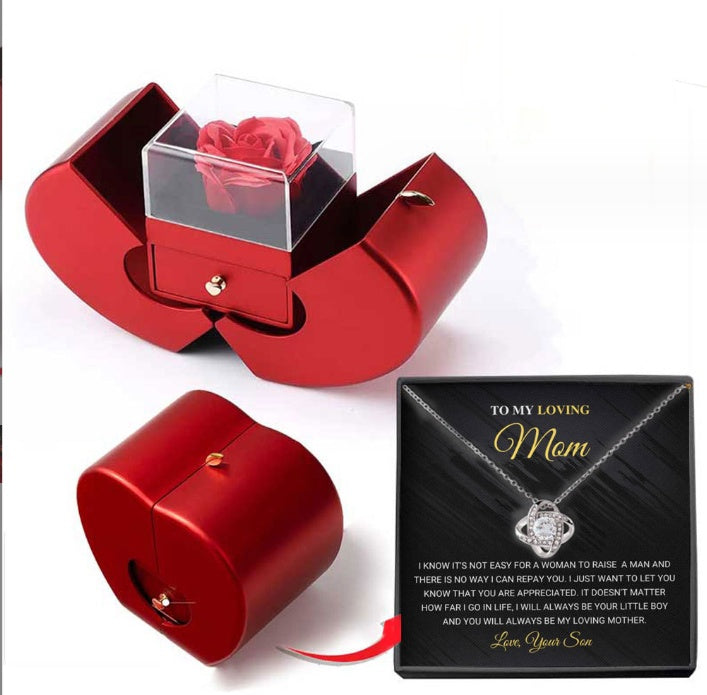 Red apple-shaped gift box containing an eternal rose and a "To My Loving Mom" necklace set in a black box.