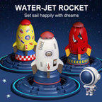 Three colorful plastic rocket sprinkler toys in yellow, white, and red on blue circular bases with an astronaut figure.