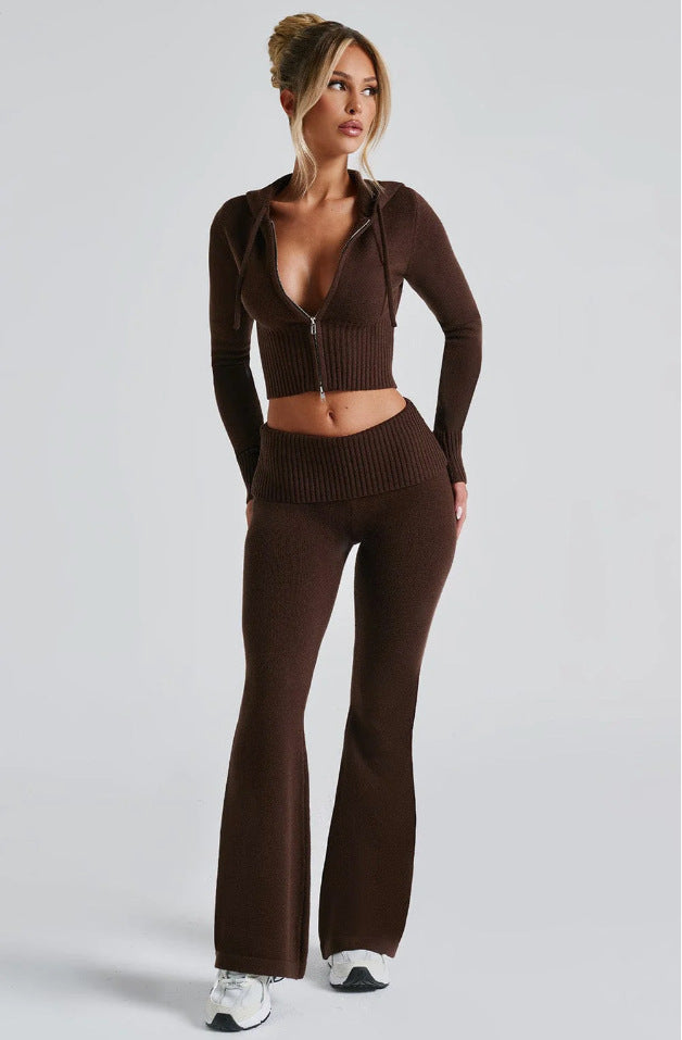 A woman wearing a brown, slim-fit, ribbed knit zip-up hoodie and matching high-waisted flared trousers.