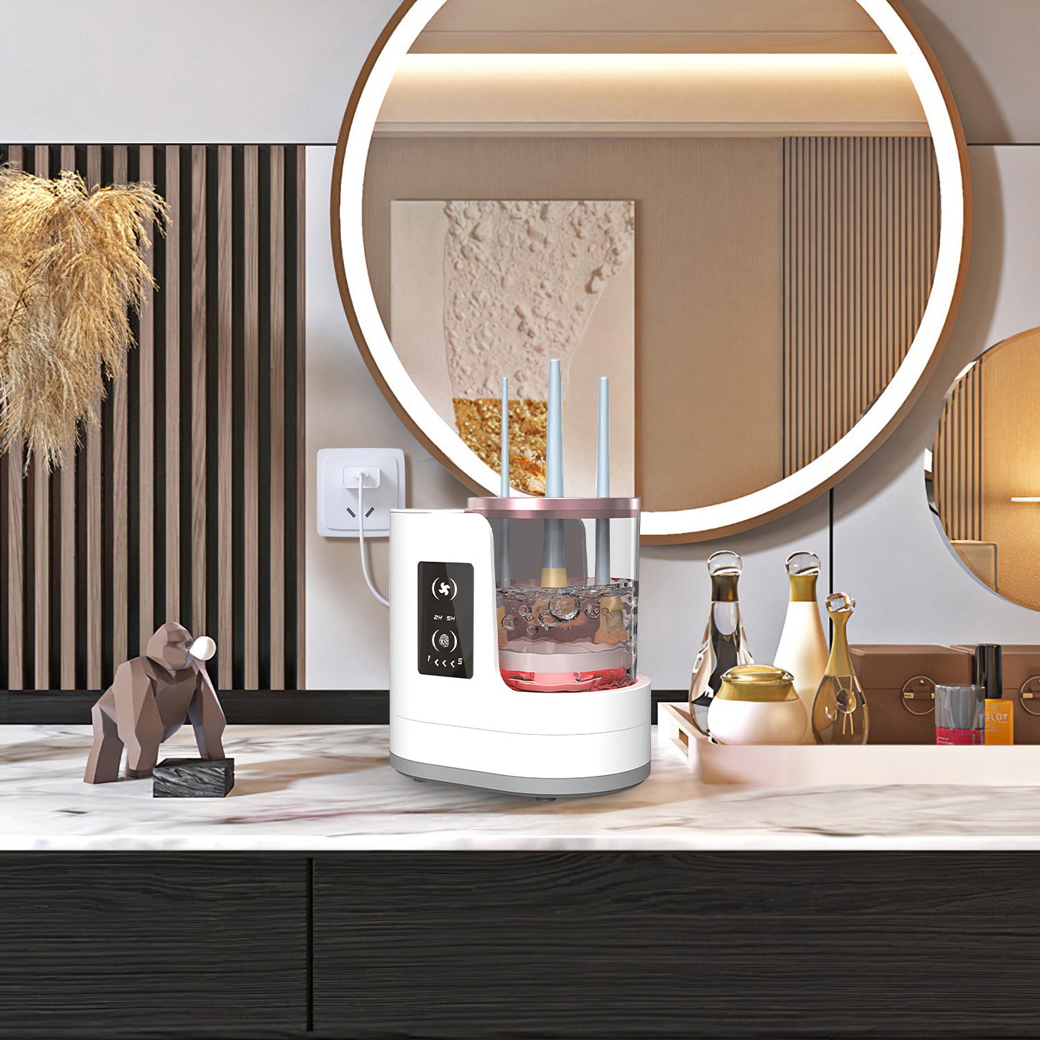 White electric makeup brush cleaner with clear basin, digital display, and rose gold trim on a marble vanity.