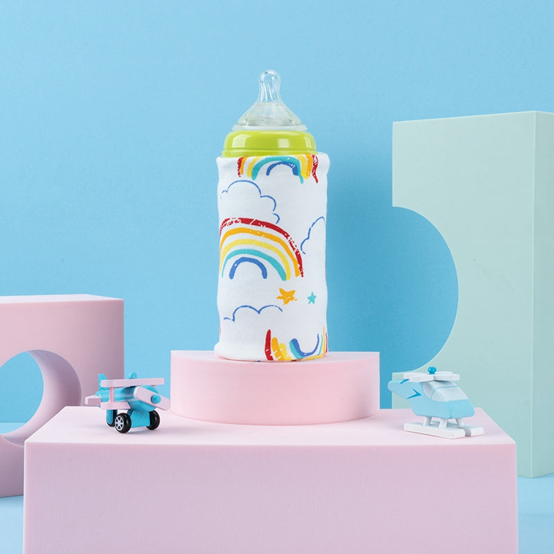 Portable USB bottle warmer with a white rainbow pattern, displayed on pink blocks with toy airplanes.