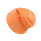A soft, solid orange newborn cotton beanie cap with a simple, relaxed, rounded design on a plain white background.