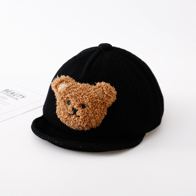 Black ribbed, thickened baby baseball cap featuring a cute, fuzzy brown teddy bear patch on the front.