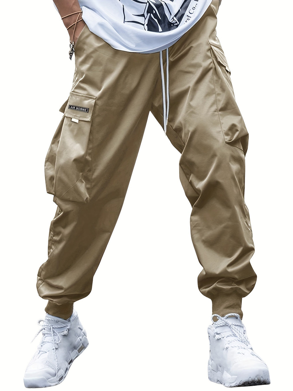 Tan cargo pants featuring a drawstring waist, side cargo pockets with "AIR BORNE" label, and ribbed ankle cuffs.