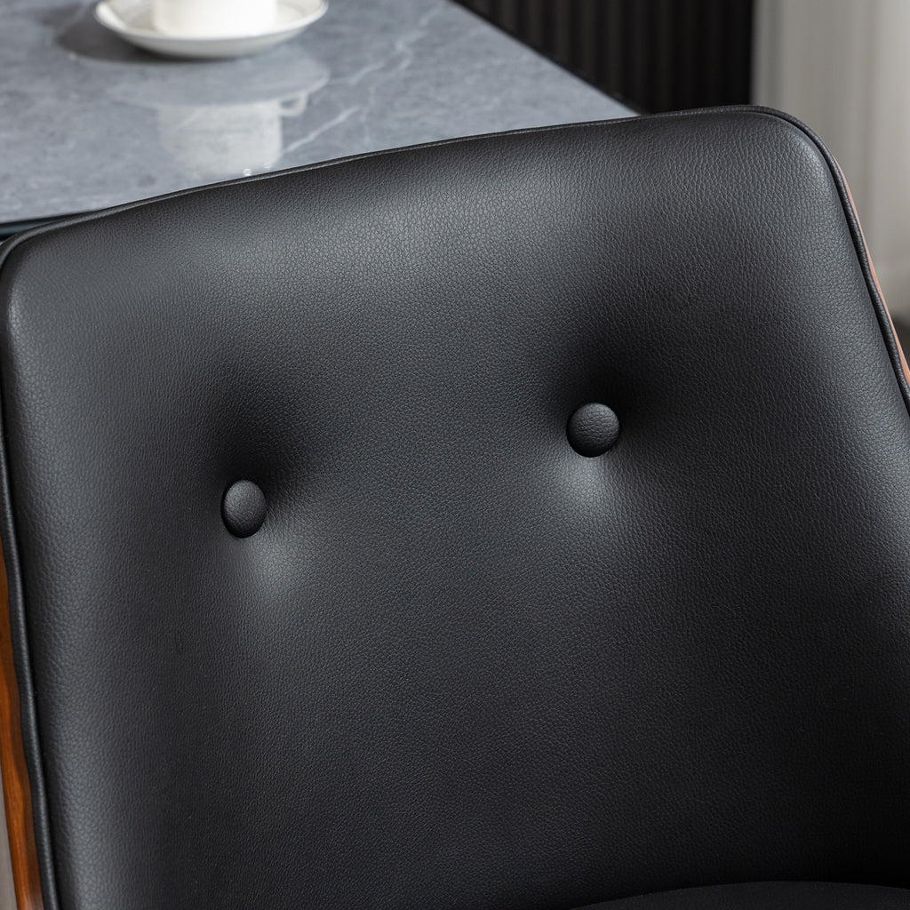 Black tufted faux leather bar stool backrest with a warm wood frame next to a grey marble tabletop.