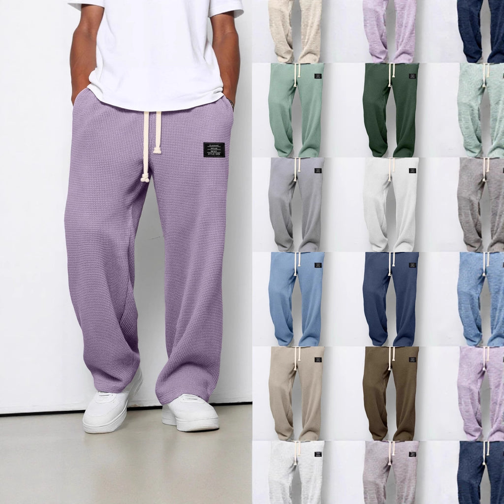 Loose-fit waffle-knit drawstring trousers with pockets, available in multiple solid colors. Includes a small logo patch.