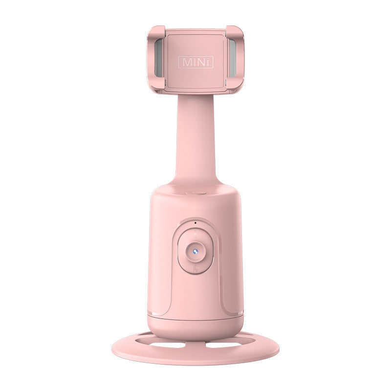 A pink, plastic 360-degree auto-tracking smartphone gimbal with a circular base, lens sensor, and adjustable cradle.