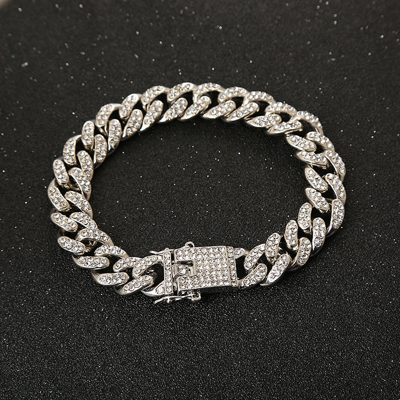 Silver-tone Cuban link chain bracelet encrusted with clear rhinestones on a black background.