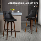Set of two black faux-leather bar stools with walnut wood curved backs and frames, featuring a swivel seat and footrest.