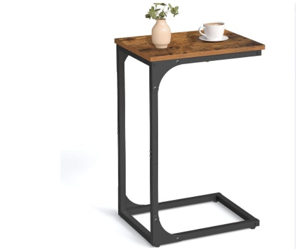 Rustic brown wood-grain C-shaped side table with black metal frame, holding a vase and coffee cup on white background.