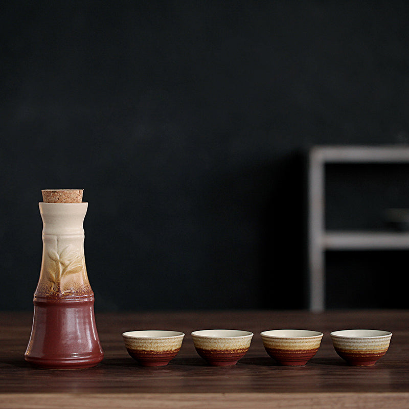 Ceramic hot wine set featuring a cork-topped decanter and four matching cups with a rustic brown and cream gradient.
