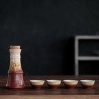 Ceramic hot wine set featuring a cork-topped decanter and four matching cups with a rustic brown and cream gradient.