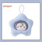 Light blue plush star-shaped hand warmer with an embroidered sleepy penguin face and a white hanging loop.