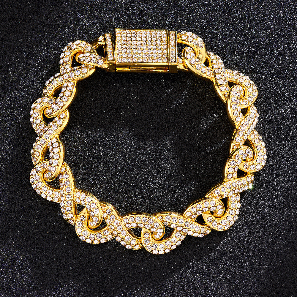Gold-tone Cuban link bracelet featuring intertwined chain design and pavé-set clear crystals on a black background.