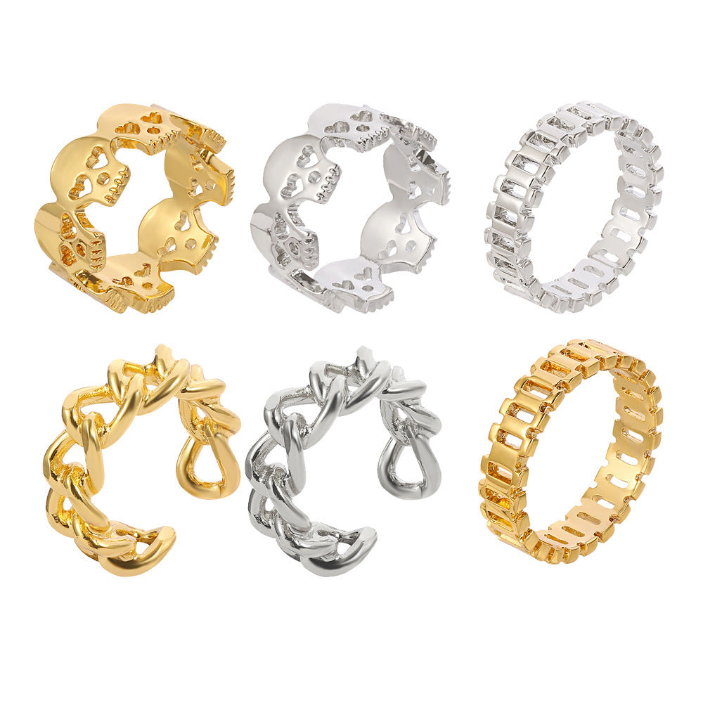 Six hip-hop style rings in gold and silver, featuring skull, chain link, and baguette diamond designs.