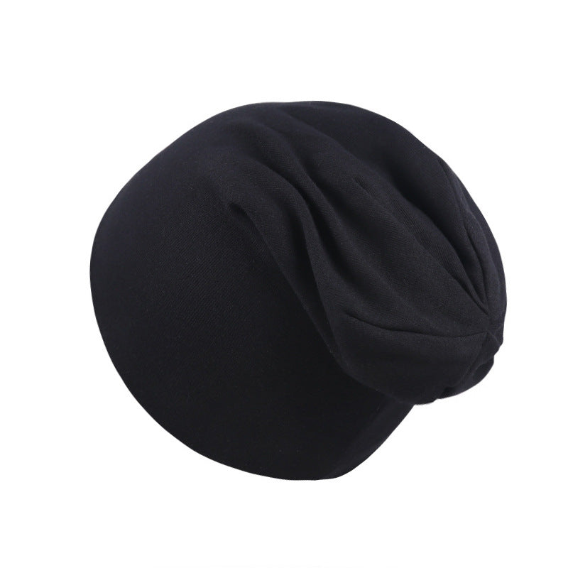 A simple, plain black newborn beanie cap made of soft, stretchable fabric with a slightly slouchy fit.