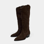 Minimalist dark brown suede high-top riding boots with a pointed toe and low block heel against a white background.