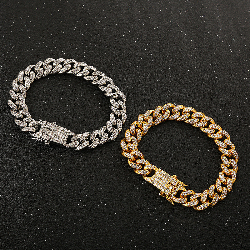 Two crystal-studded hip-hop cuban link bracelets in silver and gold tone on a black glitter background.