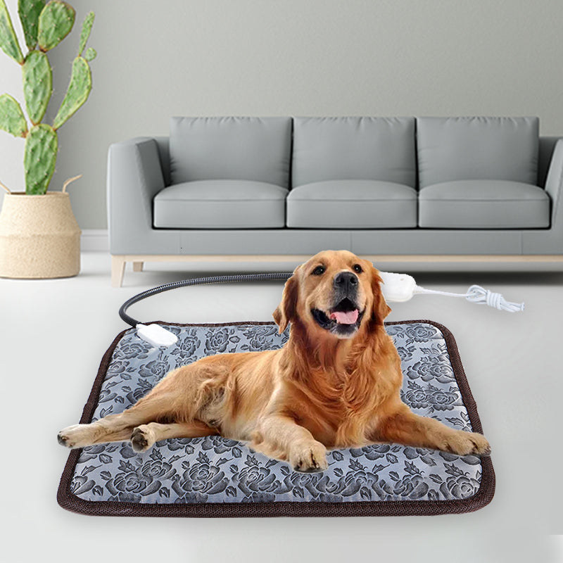 Golden retriever lying on a gray, floral-patterned, waterproof pet heating pad with a chew-resistant cord.