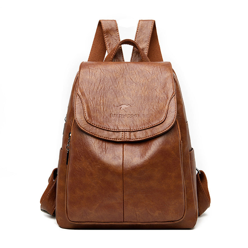 Brown faux leather backpack with a flap top, top handle, adjustable fabric straps, and embossed kangaroo logo.