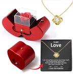 Red apple-shaped gift box containing an artificial rose, paired with a gold knot pendant necklace in a message box.