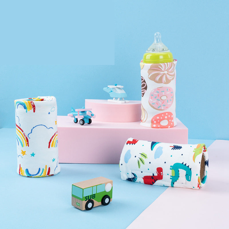 Portable USB baby bottle warmer covers in colorful donut, rainbow, and dinosaur prints on white fabric.
