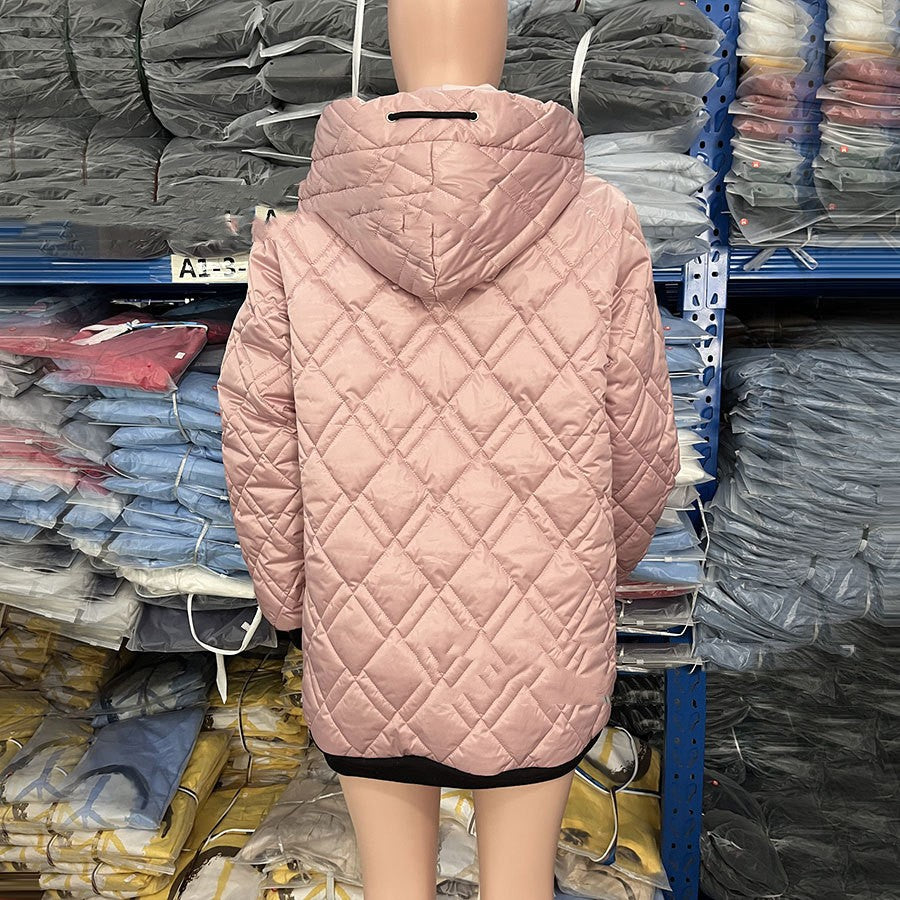 Back view of a dusty pink, quilted hooded jacket with a black drawstring, shown on a mannequin in a warehouse.