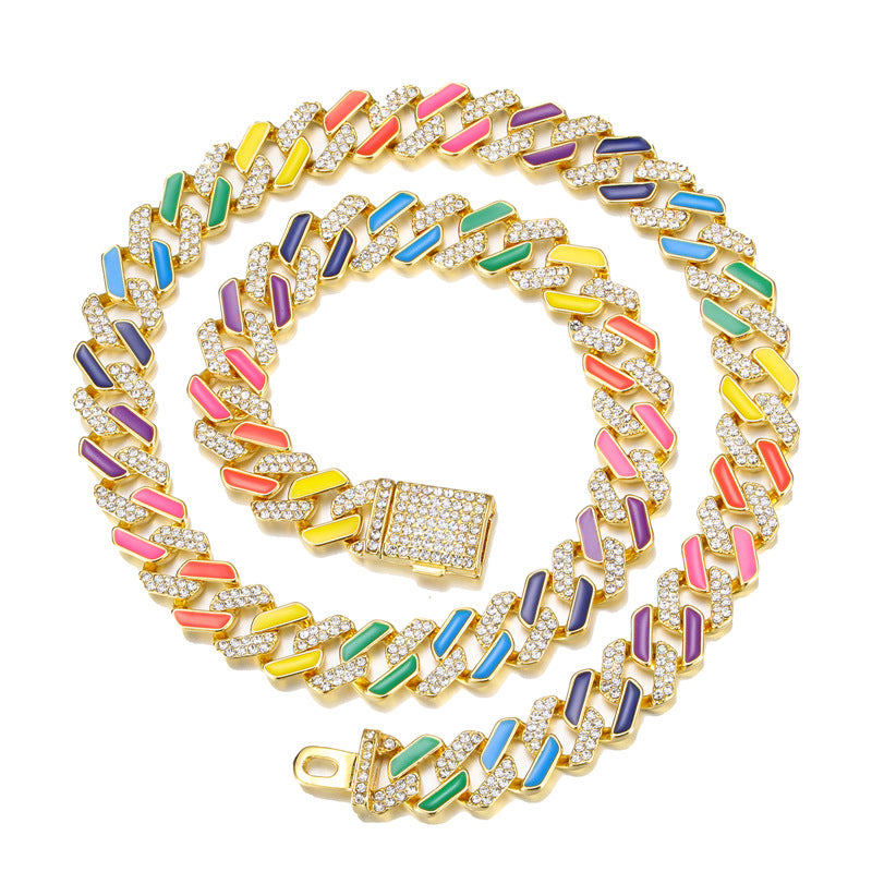 Gold Cuban chain with multicolored enamel bars and sparkling pave crystals on a white background.