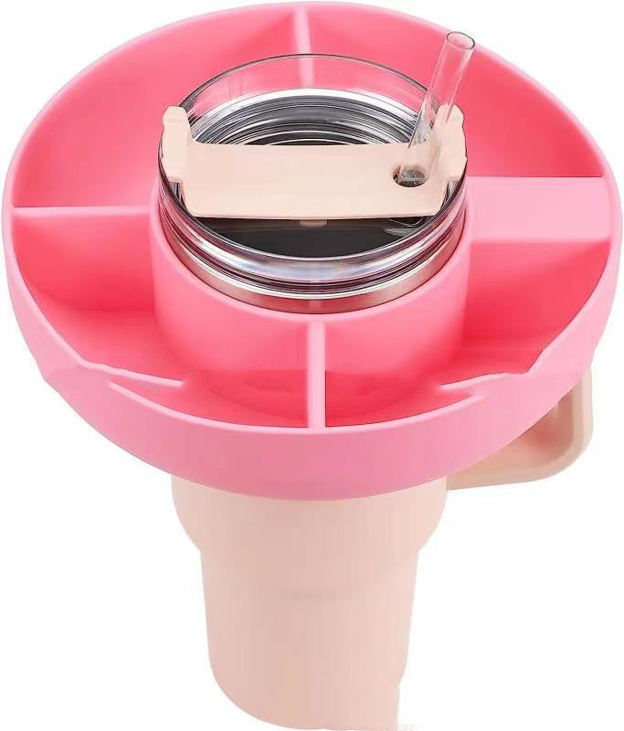 Pink 4-compartment silicone snack tray fitted onto a tumbler with a straw, providing convenient on-the-go storage.