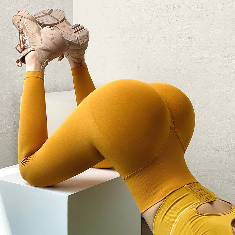 Mustard yellow high-waist fitness leggings in a stretchy, seamless fabric featuring a hip-lifting design.