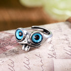 Silver hip hop ring shaped like a frog with large, vibrant blue protruding eyes and a small tongue.