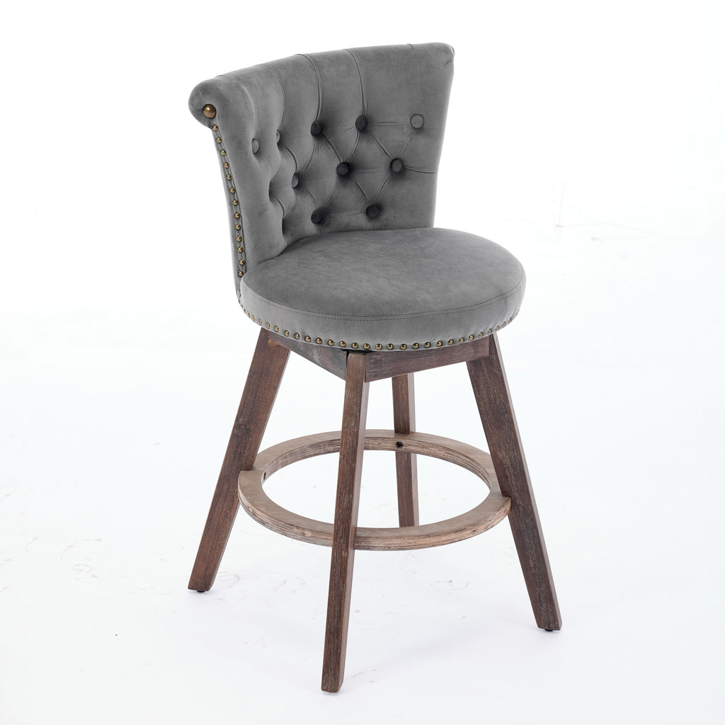 Gray velvet swivel bar stool with tufted back, nailhead trim, and dark wood legs with a round footrest.