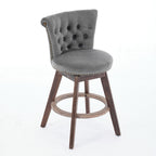 Gray velvet swivel bar stool with tufted back, nailhead trim, and dark wood legs with a round footrest.