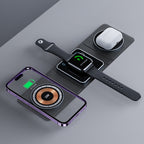 Black 3-in-1 magnetic folding charger with a purple smartphone, smartwatch, and white AirPods charging on surface.