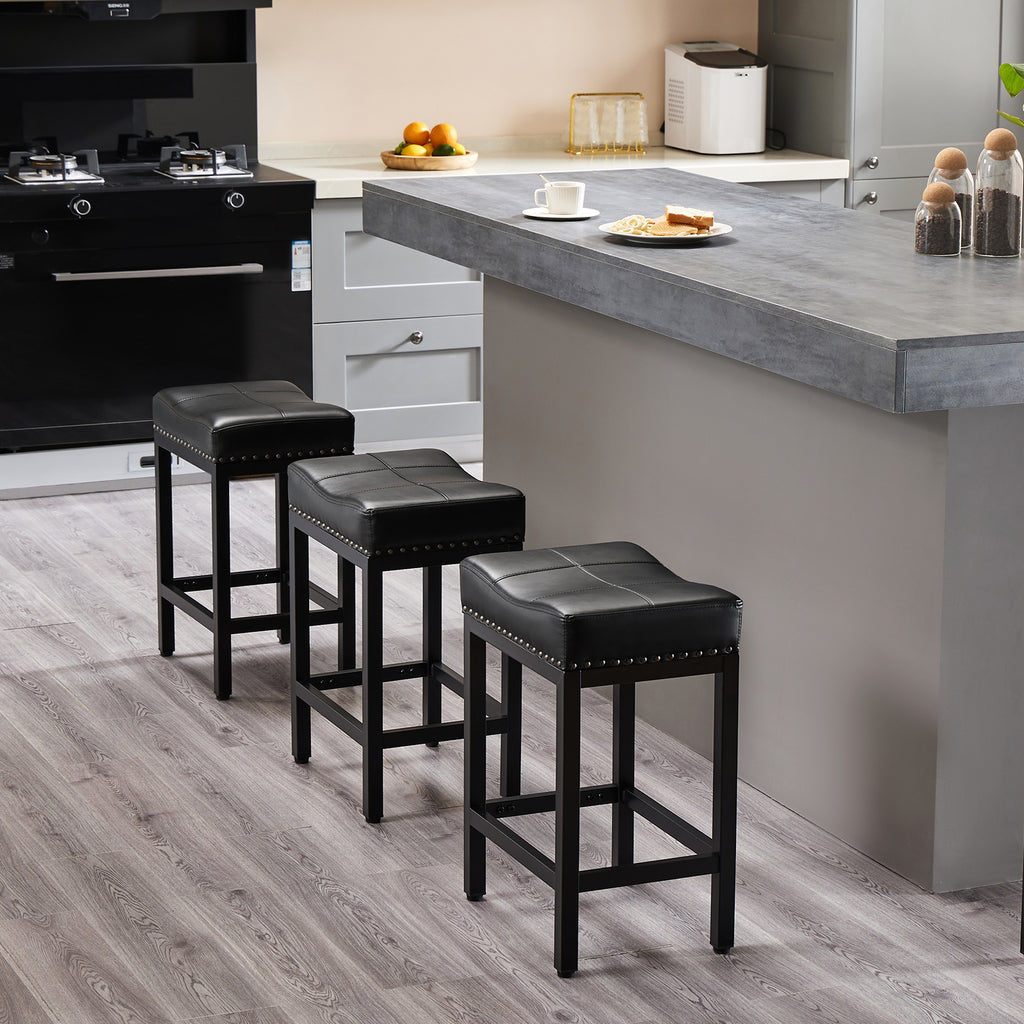 Three black saddle-style bar stools with sturdy steel frames and cushioned seats, arranged in a modern kitchen.