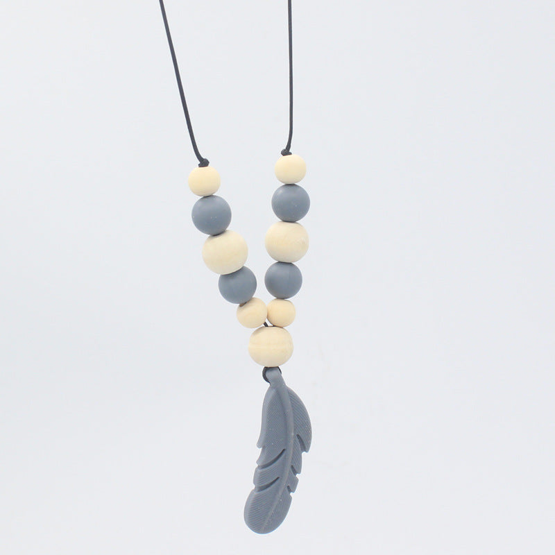Baby teether necklace with grey silicone and natural wood beads, finished with a grey silicone feather pendant.