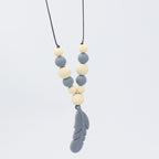 Baby teether necklace with grey silicone and natural wood beads, finished with a grey silicone feather pendant.