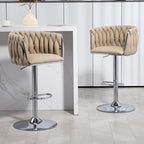 Two beige fabric swivel bar stools with woven backs, chrome adjustable pedestals, and footrests by a white island.