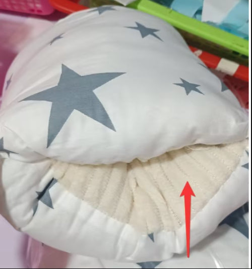 White baby nursing arm pillow with grey stars, featuring a textured, soft beige inner sleeve and red arrow indicator.